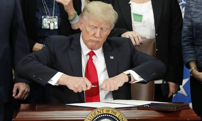 67272937 DAY 6In this Jan 25 2017 file photo President Donald Trump takes the cap off a pen b